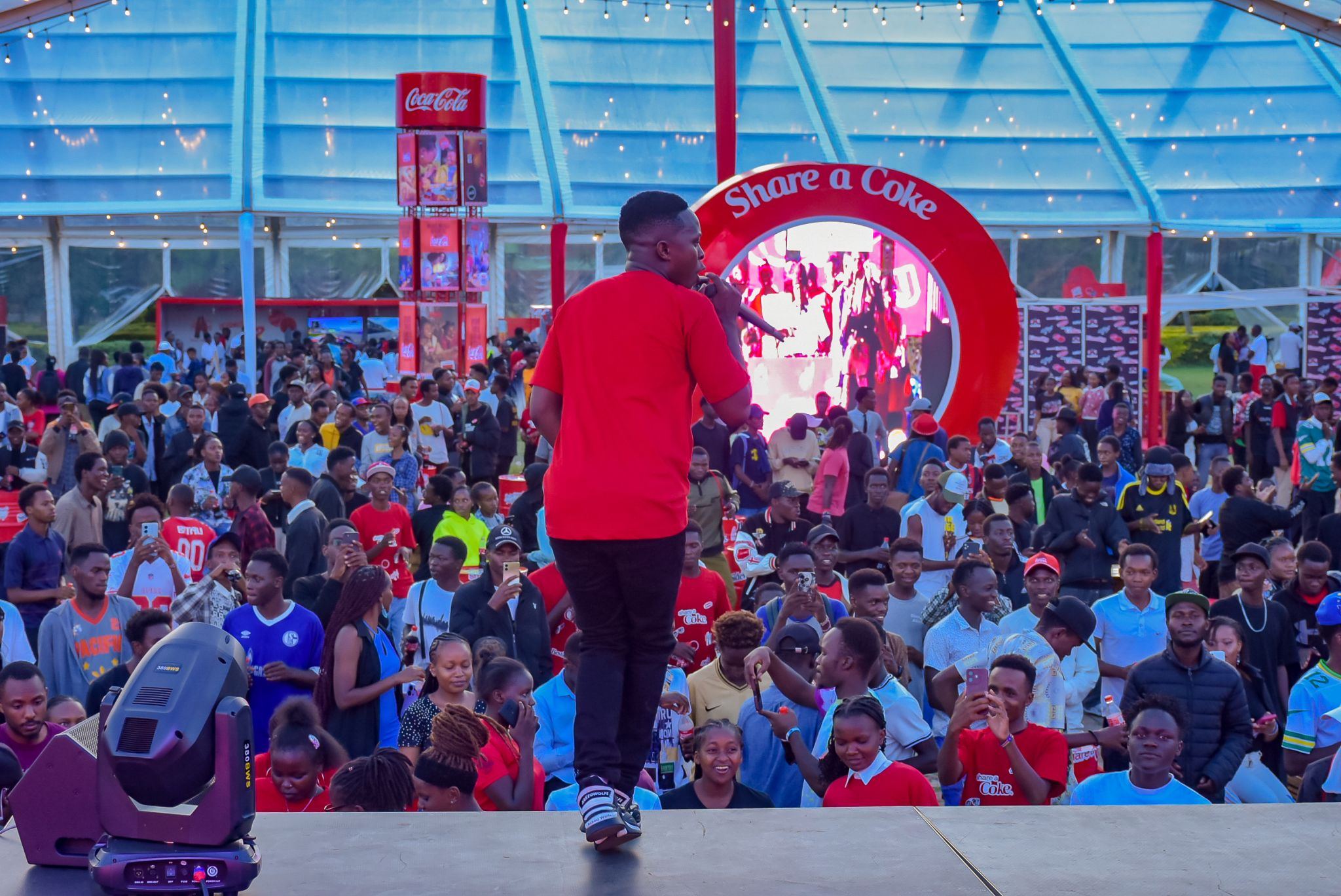 A live Share a Coke stage activation with a crowd gathered around the branded portal.